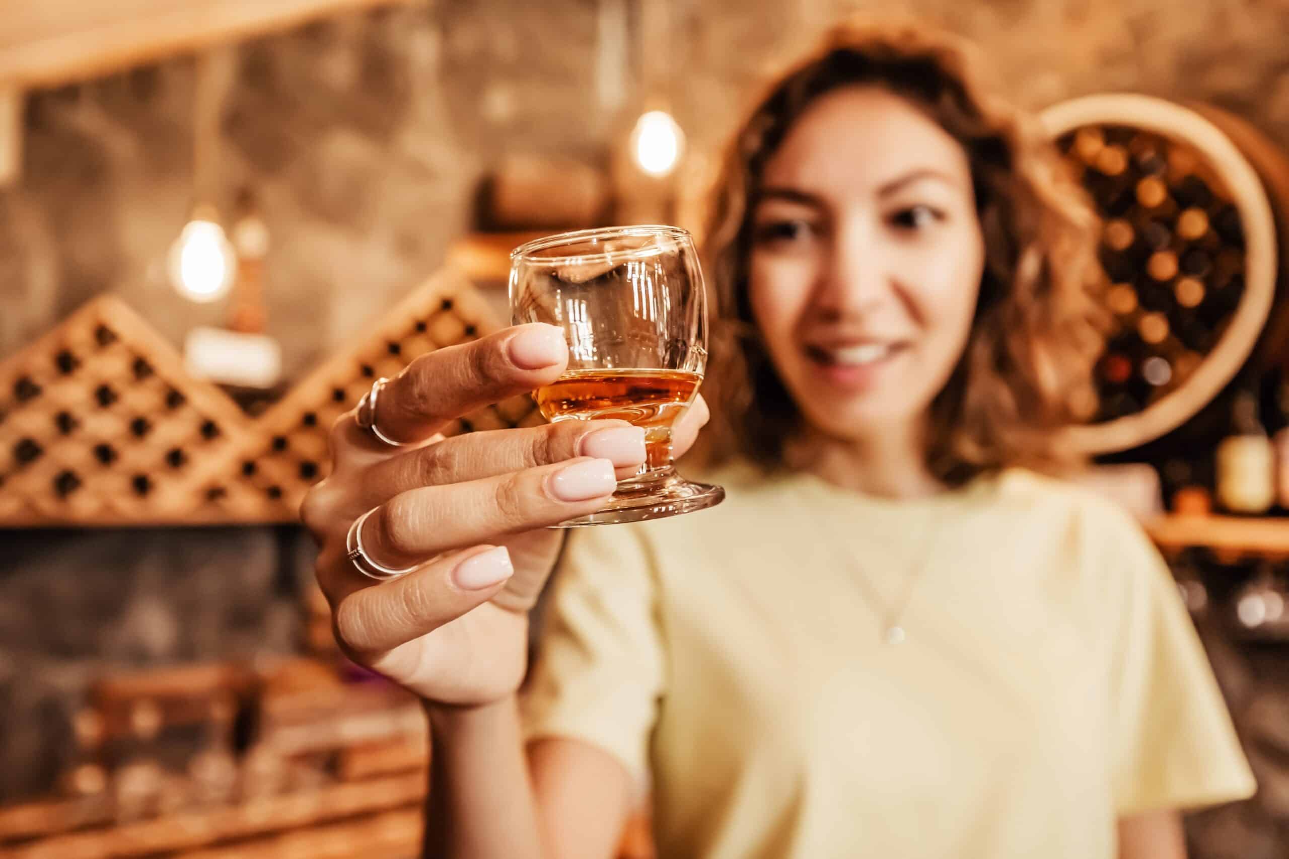 person holding glass of bourbon, charity auction travel packages, vacation fundraising, travel fundraising, fundraising ideas, charity ideas, silent auction items, travel fundraising events