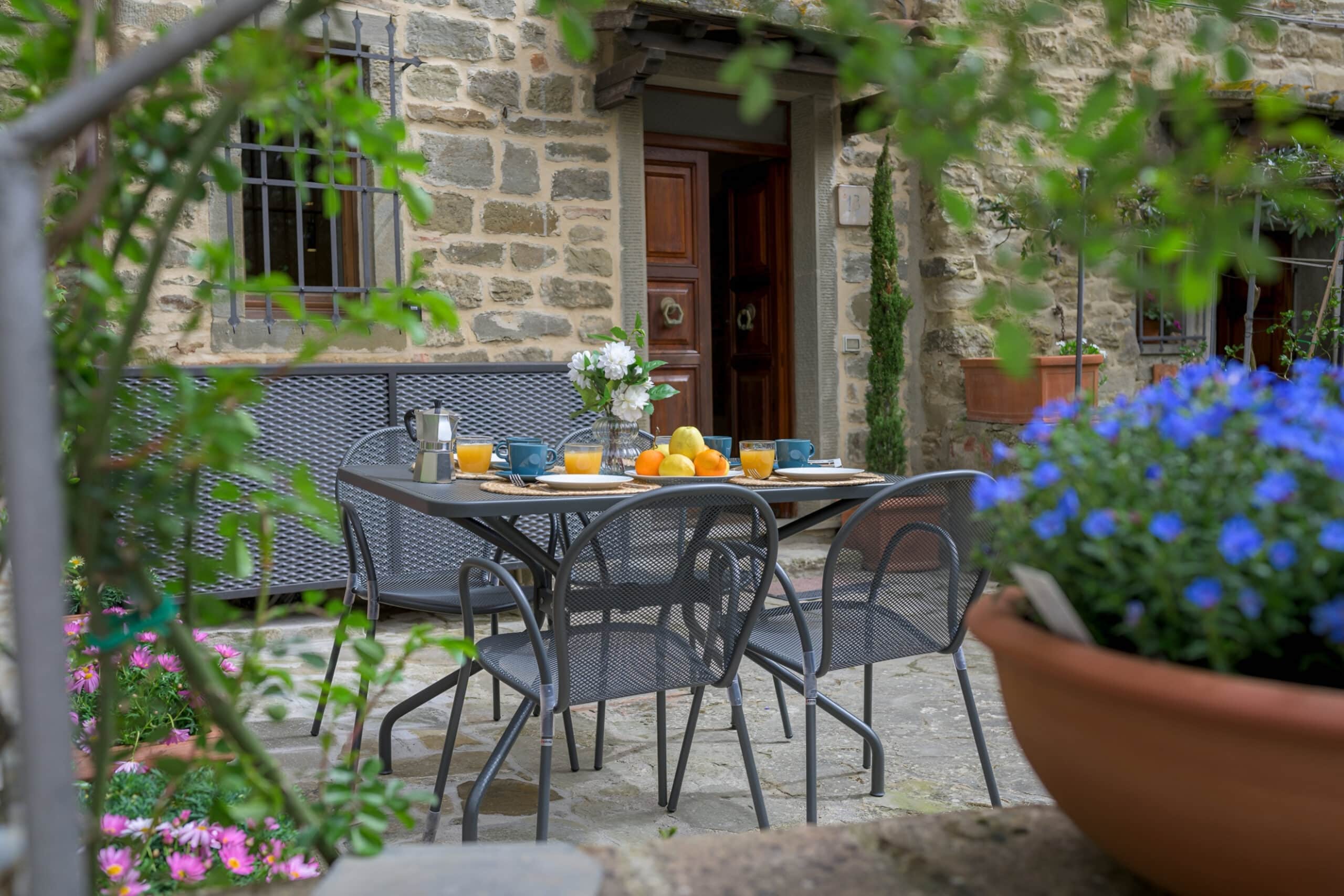 Table with food outside a building in Tuscany, charity auction travel packages, vacation fundraising, travel fundraising, auction packages for nonprofits, trips for fundraising, auction travel packages, auction vacation packages, auction packages