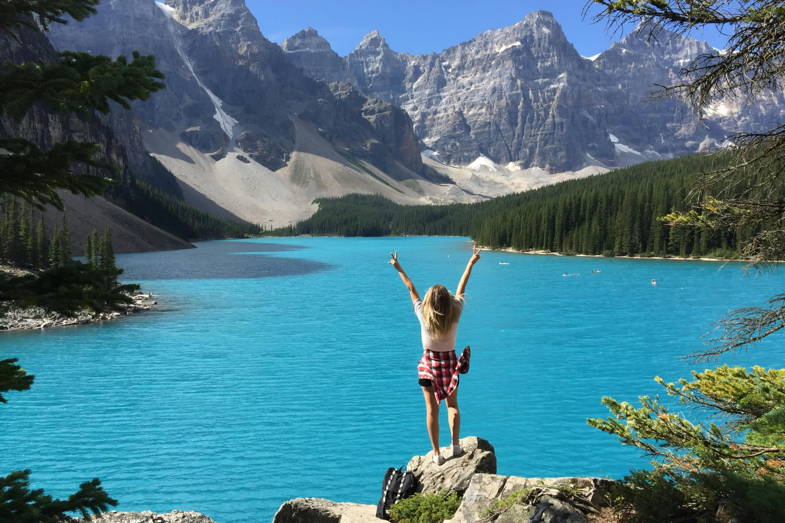 Person standing on rock overlooking lake in Banff national park, charity auction travel packages, vacation fundraising, travel fundraising, fundraising ideas, charity ideas, silent auction items, travel fundraising events